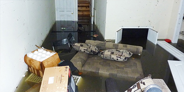 Room Filled with Standing Water and Soaked Furniture After Flood