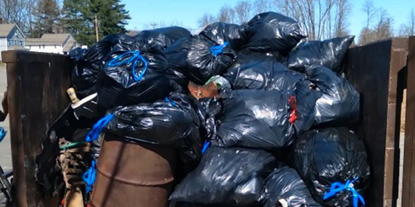 Dumpster Filled With Trash Bags and Debris