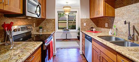 Galley Kitchen With Brown Cabinets and Granite Countertops
