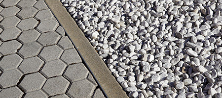 Light Gray Gravel Bordering a Concrete Driveway