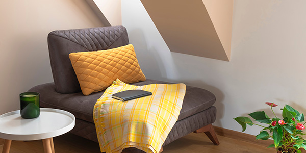 Cozy Corner Reading Nook With Gray Chair and Yellow Throw Blanket