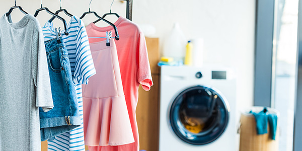 Clothes Hanging in Laundry Room Near Washer