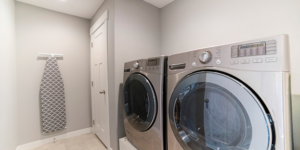 Ironing Board Hanging on Wall Next to Washer and Dryer