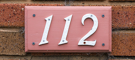 Pink and White House Numbers on Brick Wall