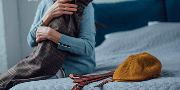 Woman Holding Loved One's Clothing During Estate Cleanout