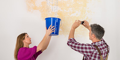 Man and Woman Work on Leaking Roof