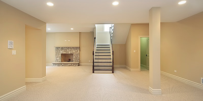 Empty Basement With Stairs and Fireplace