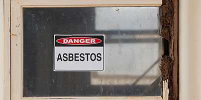 Asbestos Danger Sign on Window With Broken Sill