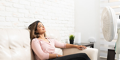 Woman Relaxing in White Room With Fan