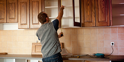 Man Removing Upper Kitchen Cabinets