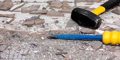 Hammer and Blue Chisel on Broken Tile