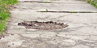 Broken Sidewalk Lined With Grass