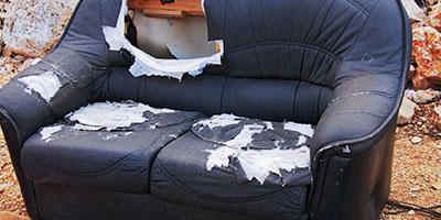 Ripped Apart Blue Couch in Front of Rubble