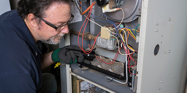 Professional Wearing Goggles and Gloves Inspecting Furnace