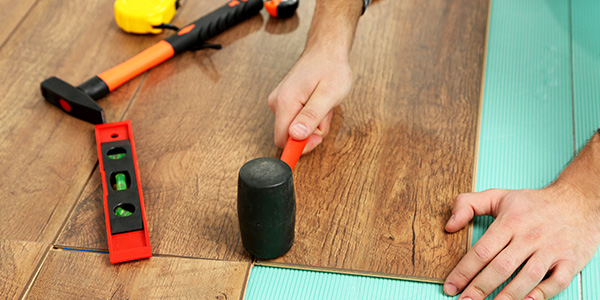 Worker Installing Basement Flooring