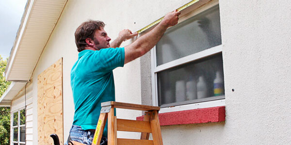 Image of a Man Installing Plywood Hurricane Shutters