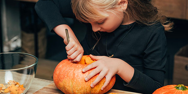 Kid Carving Pumpkin for Halloween