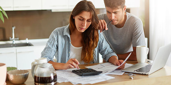 Couple Using Calculator, Pen and Paper