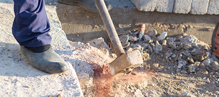 Man Using Sledgehammer to Break Concrete