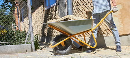 Man With Wheelbarrow Full of Concrete
