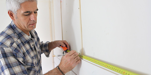 Man Measuring Kitchen Wall