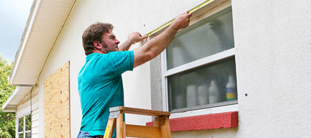 Man Installing Plywood Hurricane Shutters