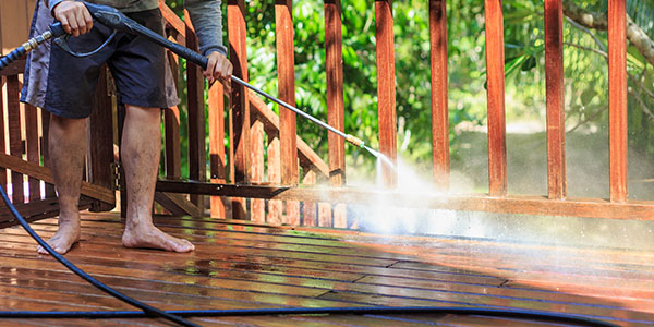 Man Pressure Washing Wood Deck