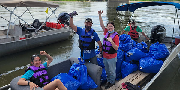 Volunteers Carry Trash Onto a Boat