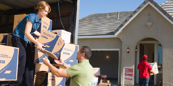 Family and Mover Unloading Boxes From Moving Truck