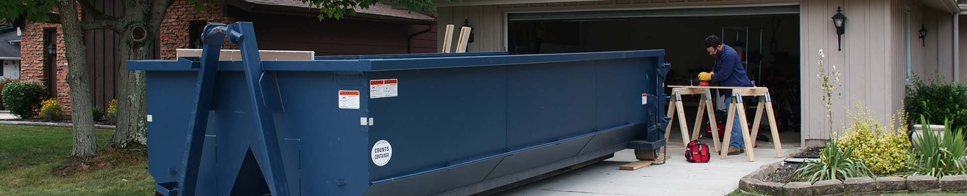 Blue Dumpster in Man's Driveway