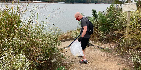 Volunteer Picking Up Trash During Community Cleanup