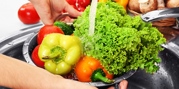 Person Washing Vegetables in Colander