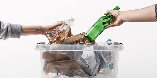 Two Hands Putting Items in Recycling Bin