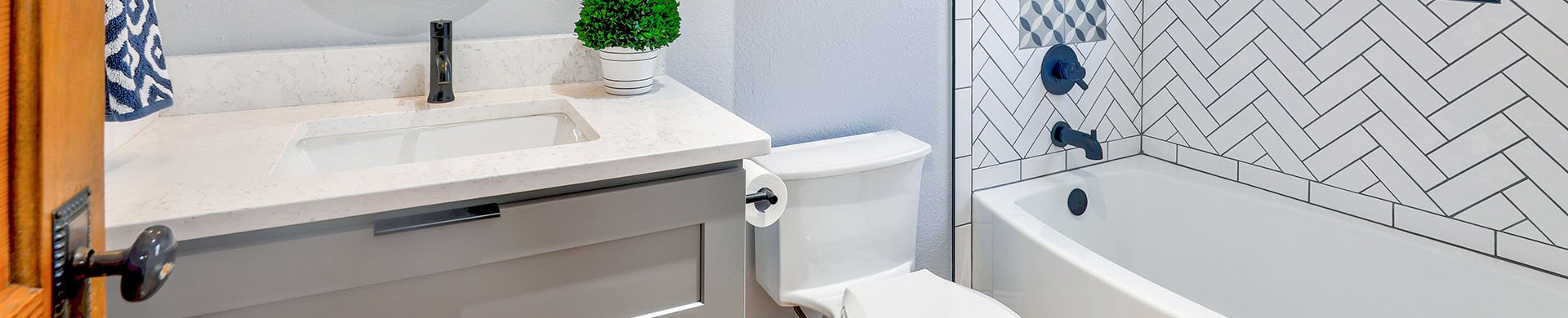 White Tiled Bathroom With Blue Accents and Oval Mirror