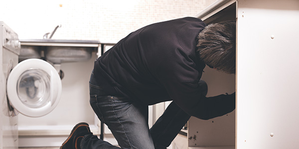 Man Removing Lower Kitchen Cabinets