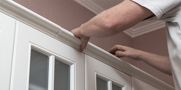 Man Removing Molding From Cabinets