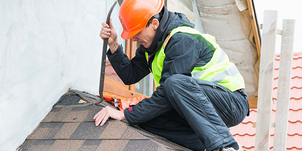 Man Removing Shingles From Roof