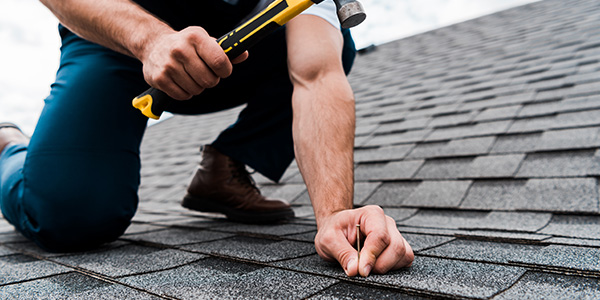 Contractor on Roof Repairing Shingles