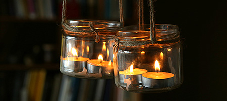 A Glass Jar With a Twine Bow, Reused as a Candle Holder