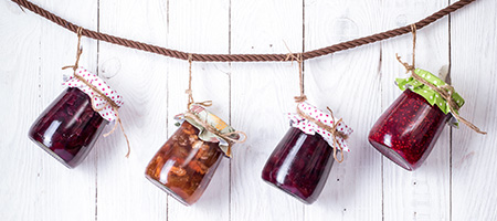 Glass Jar Fastened to a Board by a Leather Strap and Hanging on a White Wall