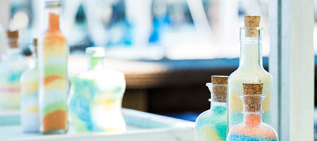 Variety of Bottles and Jars Filled With Layers of Colorful Sand