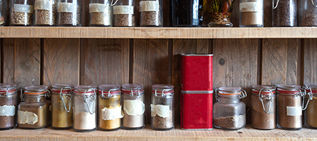 Glass Jars Filled With Spices Inside a Cupboard