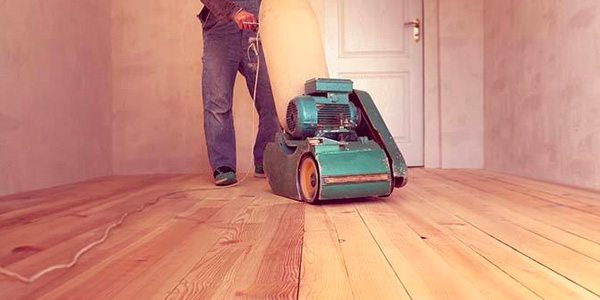 Man Using Sanding Machine on Hardwood Floor