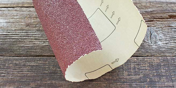 Sheet of Sandpaper on Rough Rustic Wood Floor