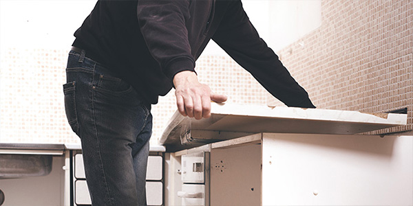 Man Removing White Kitchen Countertop