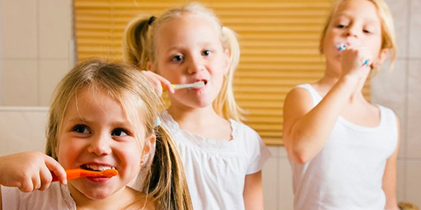 Three Young Girls Brushing Their Teeth