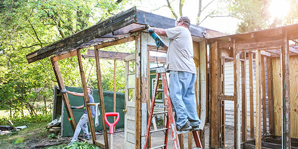 Two Men Removing Wooden Structure