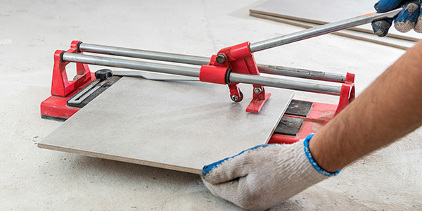 Worker Uses Tile Cutter Tool to Cut Tile