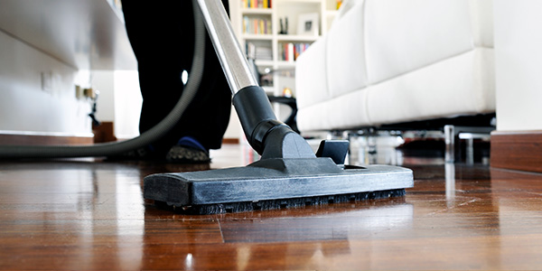 Person Vacuuming Wood Living Room Floor