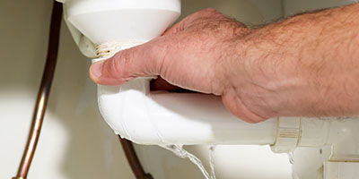 Close-Up of Hand Holding Leaky Pipe